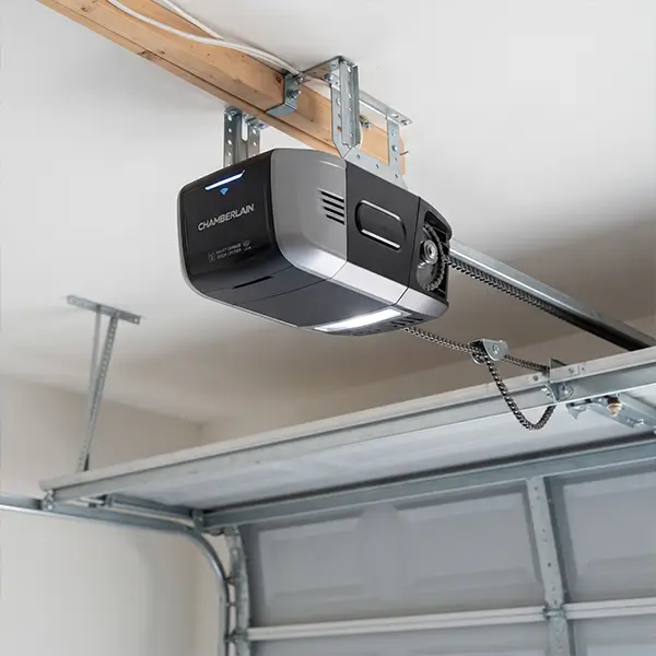 technician holding remote control and checking garage door opener motor and electrical components